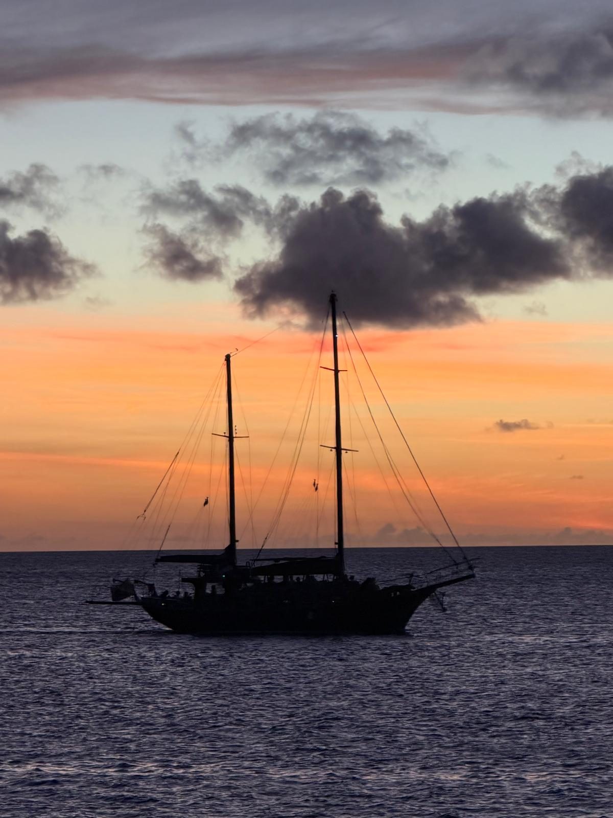 Silhouet van een zeilschip bij zonsondergang voor de kust van Bonaire